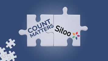 Puzzle pieces with logos of CountMatters and Sitoo fitting together, symbolizing their integration and partnership on a dark blue background.