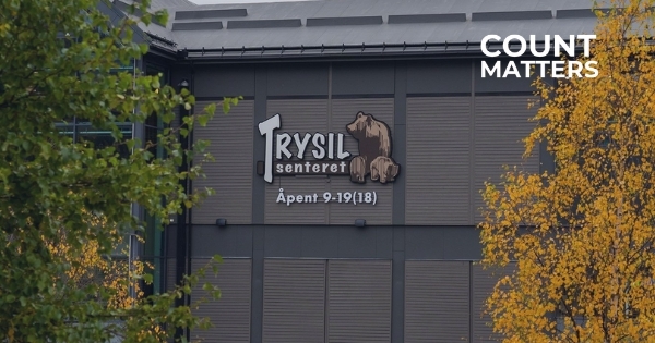 Exterior of Trysil Shopping Center with bear logo and opening hours sign, ideal for illustrating visitor counting, footfall analytics, and shopping center performance optimization with CountMatters, logo in corner.