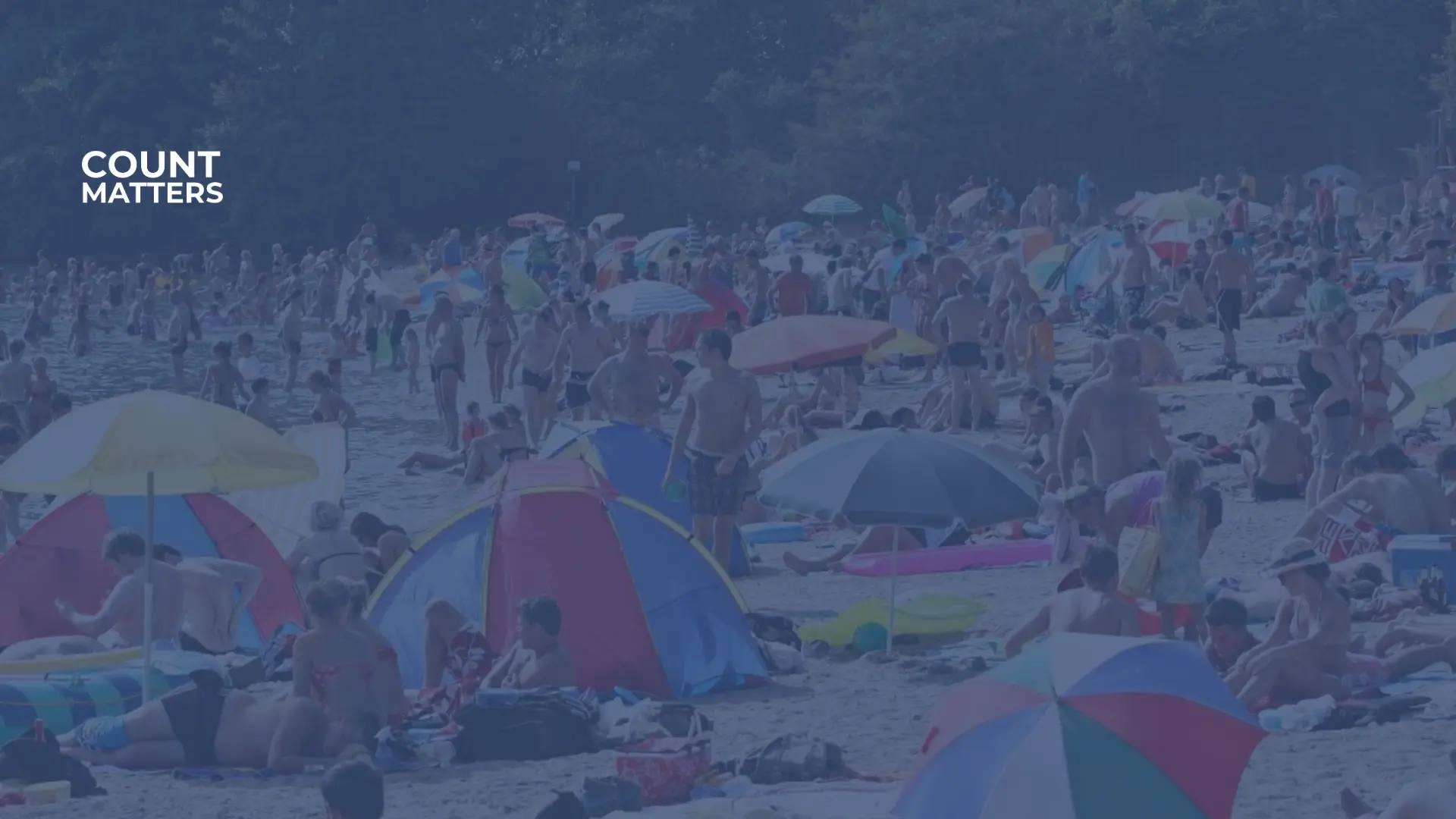 Travel strand en sommerdag med mange mennesker og parasoller, brukt til å analysere besøksmengder og kapasitetsstyring i uteområder med CountMatters.