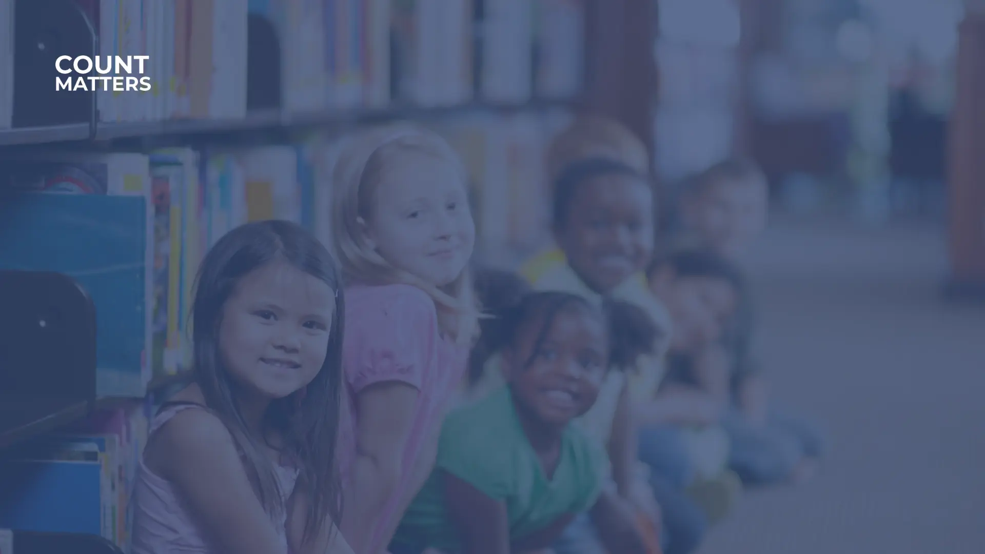 Kinder, die in einer Bibliothek in der Nähe von Bücherregalen sitzen, zur Veranschaulichung der Besucherzählung und der Belegungsdaten in öffentlichen Lernräumen mit CountMatters.