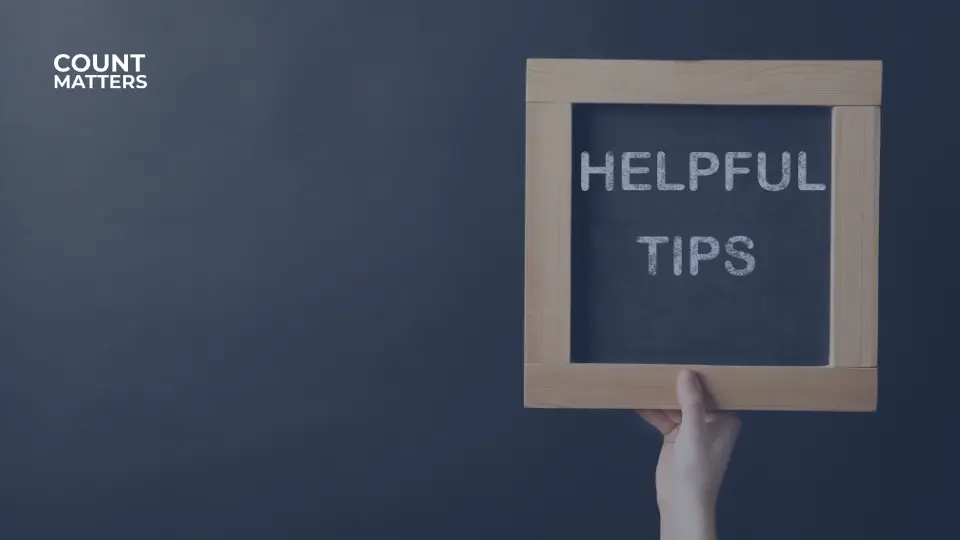 Hånden holder en lille kridttavle med ordene "Helpful Tips", som repræsenterer praktiske råd og indsigter fra CountMatters.