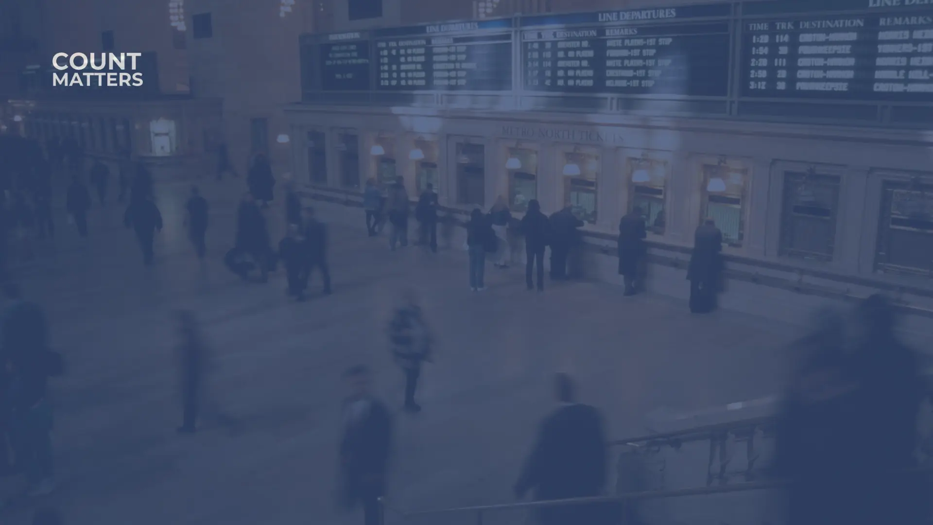 Passasjerer som beveger seg gjennom en stor billetthall på en togstasjon, brukt til å analysere passasjerflyt og stasjonsbelegg med CountMatters.